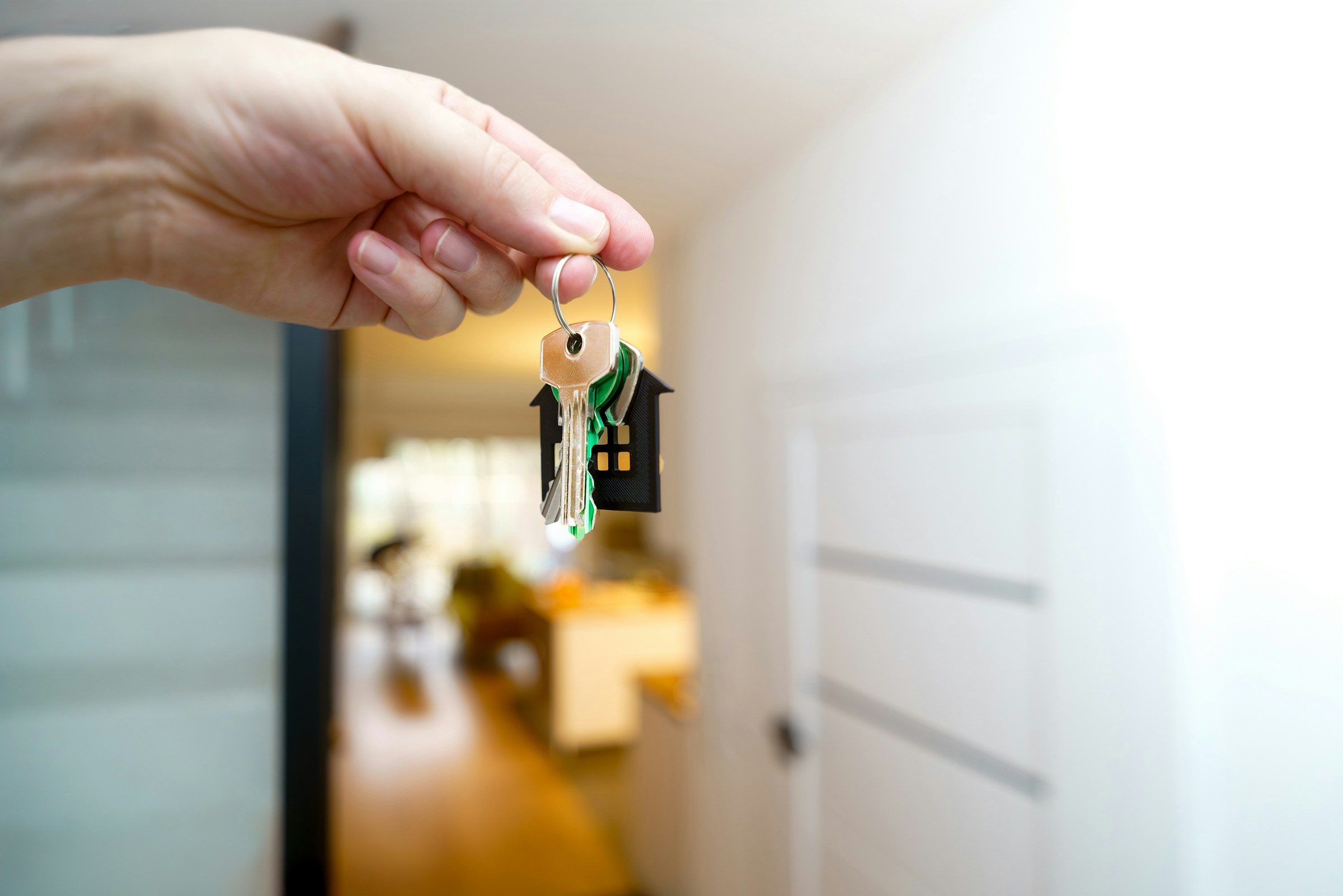 House keys held up at an open front door